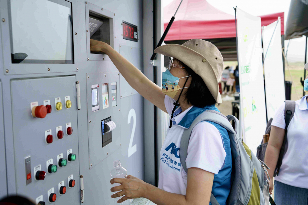 志工們將拾起的寶特瓶投入「好歸塑專車」，讓廢棄塑料空瓶可以直接粉碎、縮小體積，未來(lái)將可再製成購(gòu)物袋、寶特衣、悠遊卡等生活用品